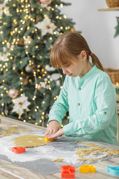 Enfant fille préparer des biscuits au gingembre pour les vacances de Noël et jouer avec des emporte-pièces. Temps de Noël. - Photo, image