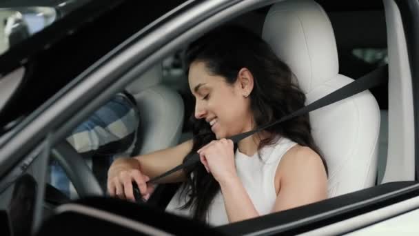 Χαμογελαστή κυρία που χρησιμοποιεί ζώνη ασφαλείας πριν από το μάθημα οδήγησης με τον αρσενικό εκπαιδευτή. Δοκιμή οδήγησης, έννοια μεταφοράς. Αργή κίνηση - Πλάνα, βίντεο