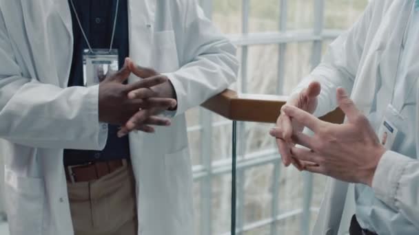 Schnappschuss multiethnischer medizinischer Mitarbeiter, die in der Halle der Klinik miteinander kommunizieren - Filmmaterial, Video
