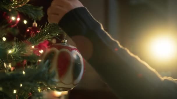 Kind schmückt Weihnachtsbaum mit Kugeln .  - Filmmaterial, Video