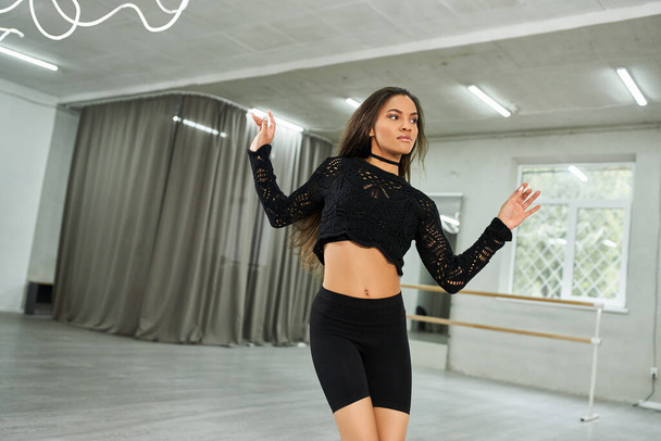 wdzięk długowłosy afrykański tancerz amerykański w czarny strój próby w studio tańca, kreatywność - Zdjęcie, obraz