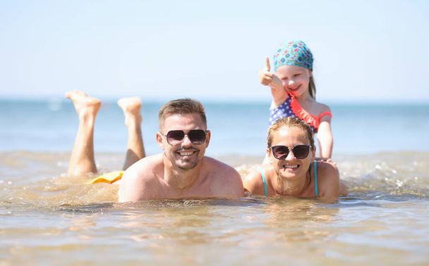 Gezin met klein meisje in zee. Familie vakantie concept - Foto, afbeelding