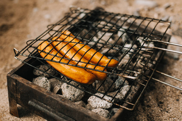 Delicious grilled sausage on a barbecue. Picnic menu. Selective focus. - Foto, Imagen