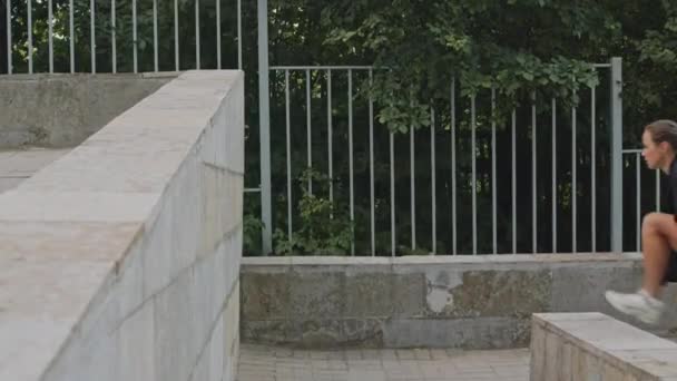 Widok z boku strzał sportowy biały dziewczyna ściana wspinaczka na zewnątrz w mieście w dzień - Materiał filmowy, wideo
