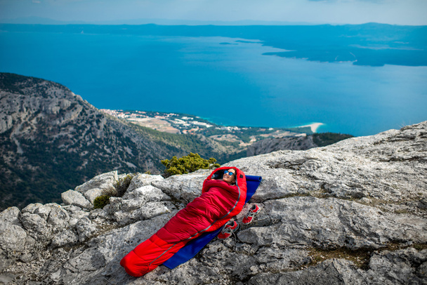 Femme dans un sac de couchage sur la montagne
 - Photo, image
