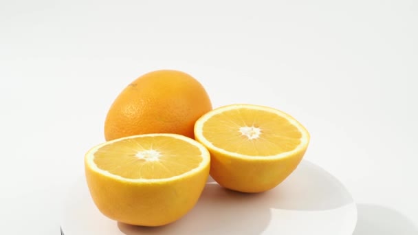 Rijpe sinaasappels draaien op een witte achtergrond. Sinaasappels close-up op wit. - Video