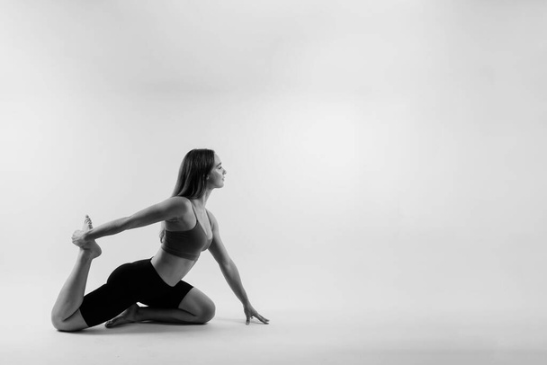 Belle femme faisant Lotus de Padmasana ou Kamalasana pose sur un cours de yoga. Plan studio. - Photo, image