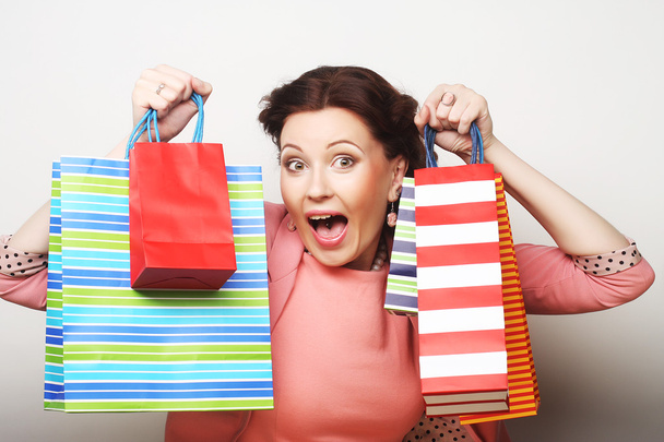 beautiful young woman with colored shopping bags - 写真・画像