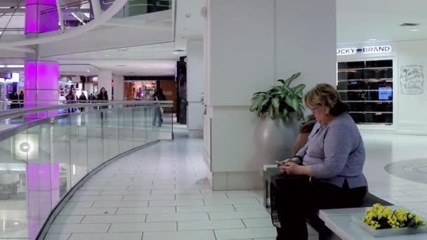 Sprawdzanie wiadomości cellphone wewnątrz centrum handlowego kobieta - Materiał filmowy, wideo