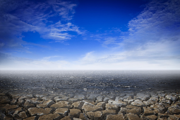 Tierra seca con agua y cielo azul
 - Foto, imagen