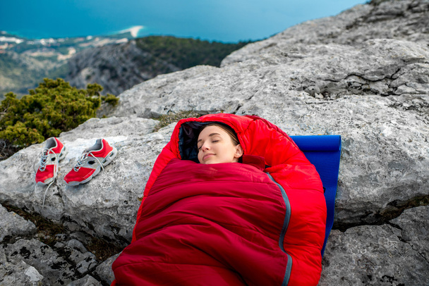 Vrouw in slaapzak op de berg - Foto, afbeelding