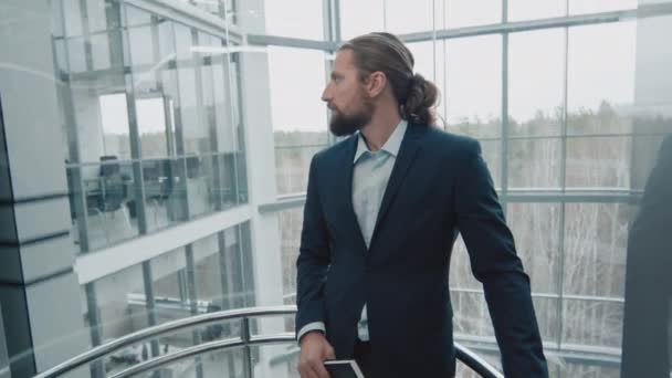Mannelijke ondernemer met dagelijkse planner in handen met behulp van lift in modern kantoor - Video