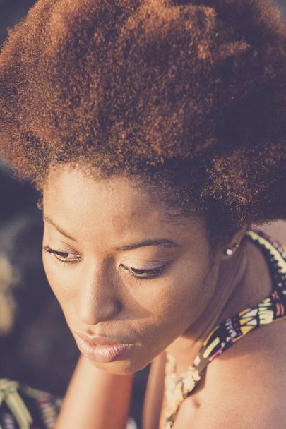 Modeporträt einer attraktiven schwarzen jungen Model-Frau mit ethnischer Afro-Frisur und afrikanischem Kleid. Schöne Mädchen allein von oben betrachtet. Hübsche Person in traditioneller afrikanischer farbenfroher Kleidung - Foto, Bild
