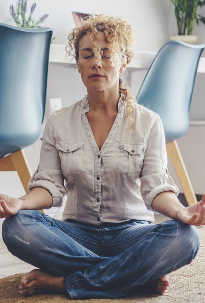 Zen gesunde Frauen machen Yoga und Meditation zu Hause auf dem Teppichboden - erwachsene Frau und psychische Gesundheit oder positive Freizeitaktivität im Lebensstil - schöne Dame sitzt mit geschlossenen Augen und Lotus ausgewogene Haltung - Foto, Bild