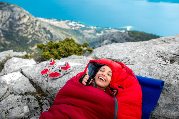 Woman in sleeping bag on the mountain - 写真・画像