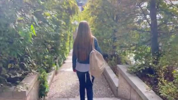 A woman with a backpack is a traveler walking down the stairs. Travel concept. - Footage, Video