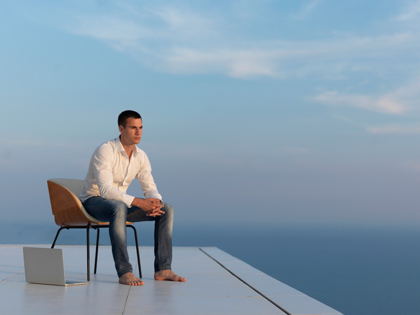 Entspannter junger Mann auf dem heimischen Balkon - Foto, Bild