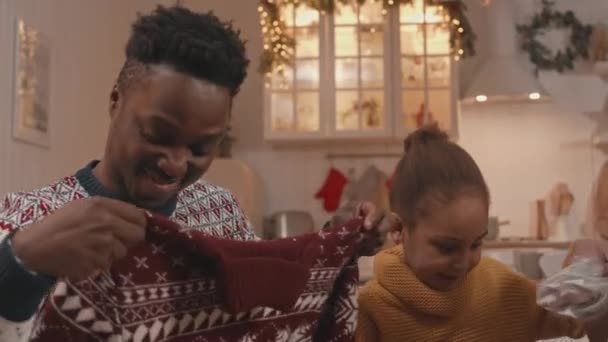 6歳の娘と陽気なアフリカ系アメリカ人の家族のショットを待ってクリスマスプレゼントをパックし,Xmas Eveでお互いに与えました - 映像、動画