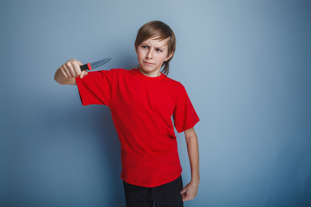 boy teenager European appearance in a red shirt brown hair looks - Photo, Image