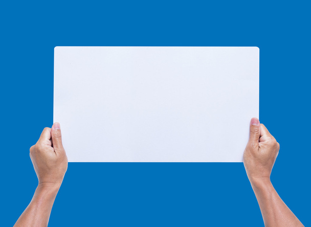 Mãos segurando papel em branco isolado no fundo azul
 - Foto, Imagem