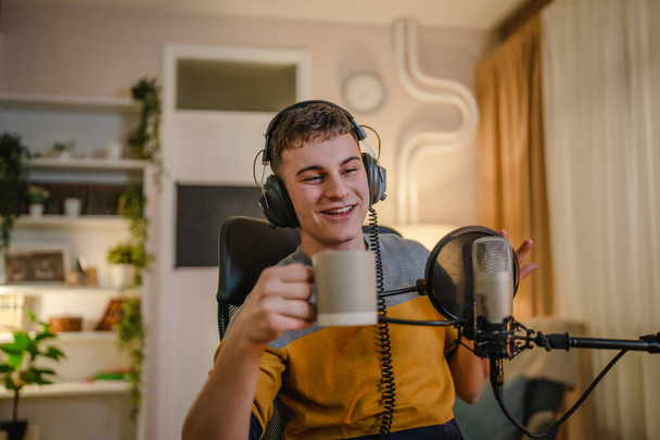 One man caucasian male blogger or vlogger gesticulating while streaming video podcast in broadcasting studio use microphone and headphones famous influencer shooting video for channel podcast - Fotoğraf, Görsel