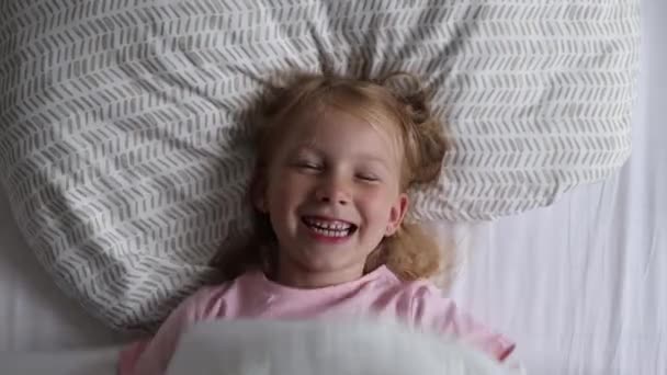 Κορίτσι που παίζει με μια κουβέρτα στο κρεβάτι - Πλάνα, βίντεο