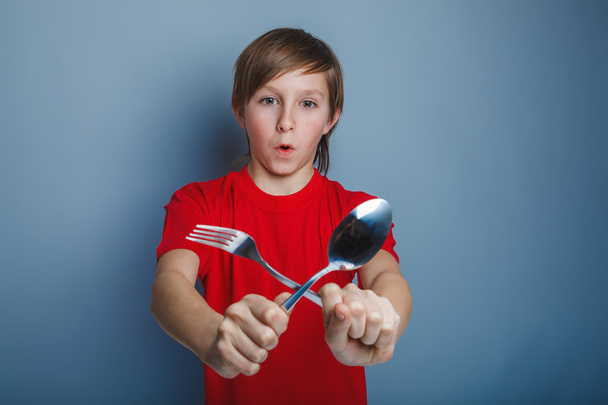jongen tiener Europese verschijning in een rood shirt houden een vork een - Foto, afbeelding