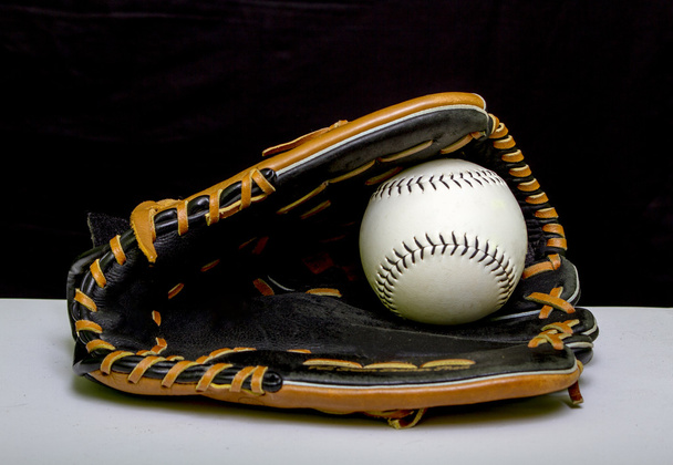 Slowpitch Softball Handschuh mit weißem Softball im Gurt - Foto, Bild