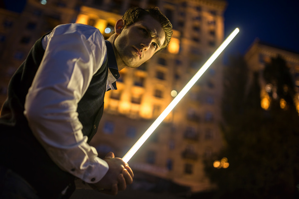 Handsome guy holding a lightsaber Jedi - Photo, Image