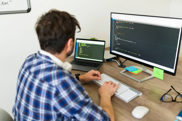 Іспаномовний програміст, який друкує і пише новий код на комп'ютері під час роботи в офісному коді розробки нового програмного забезпечення - Фото, зображення