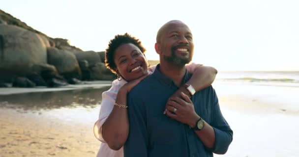 Happy couple, embrace or hug with smile on beach vacation, trip or travel to coast. Mature, black man and woman with excited emoji on face with holiday for relaxing, calm and peace in bond together. - Footage, Video
