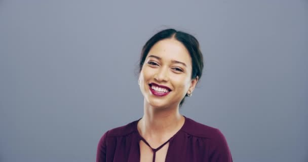 Happy woman, thumbs up and excited for success, winning and like emoji or vote for makeup review in studio. Face of cosmetics model or winner laughing, yes hands or agreement on a gray background. - Footage, Video