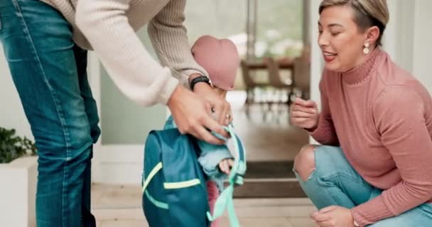 Parents, child and backpack for kindergarten, hug at home, getting ready and happy family in morning. Mom, dad and kid, helping with school bag for daycare, learning and and development with love - Footage, Video