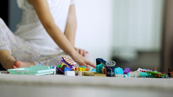 Nahaufnahme von kleinen Mädchen spielen mit kleinen Konstrukteur Spielzeug auf dem Boden im heimischen Wohnzimmer, Lernspiel, verbringen Freizeitaktivitäten Zeitkonzept. Hochwertiges 4k Filmmaterial - Filmmaterial, Video