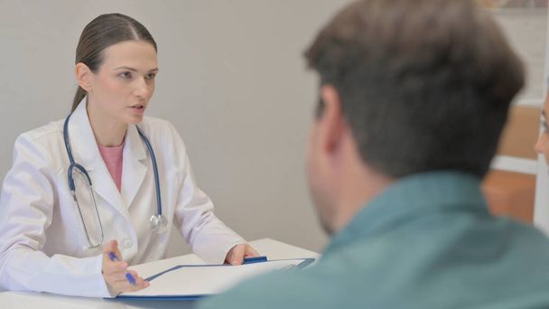 Ärztin diskutiert medizinischen Bericht mit Patientin - Foto, Bild