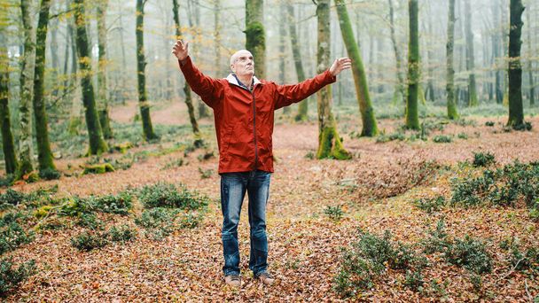 Ηλικιωμένος άνθρωπος αναπνέει φρέσκο και καθαρό αέρα στο ορεινό πάρκο. - Φωτογραφία, εικόνα