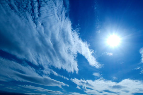 el Sol y las nubes blancas esponjosas sobre el cielo azul
 - Foto, Imagen