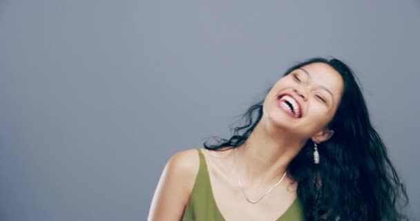 Face, happy or woman in studio laughing at joke or crazy comedy isolated on gray background. Funny, excited model or silly female person with freedom, goofy smile or joy to relax alone with humor. - Footage, Video