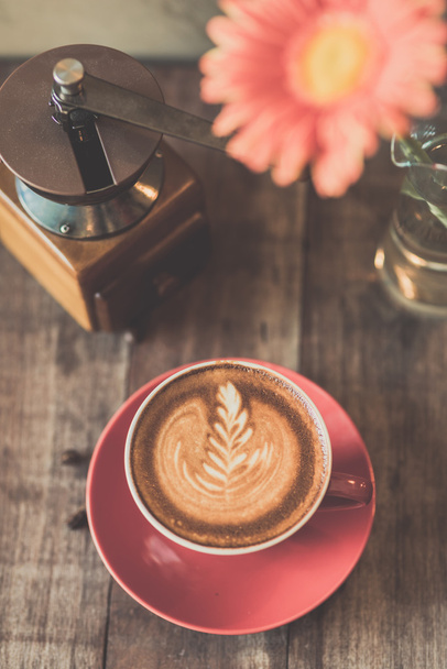 Red coffee mug , coffee grinder on wooden background. - Fotó, kép