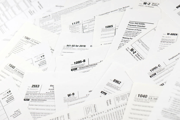 Многие бланки налоговых форм лежат на столе крупным планом. Бумажная рутина налогоплательщиков и концепция бюрократии. Нужна помощь с налоговыми проблемами
 - Фото, изображение