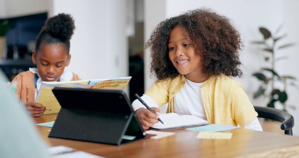 Kids, e learning and tablet with writing, book and reading for education, development and study at desk. Children, touchscreen and notebook with smile, online course and home school in family house. - Photo, Image