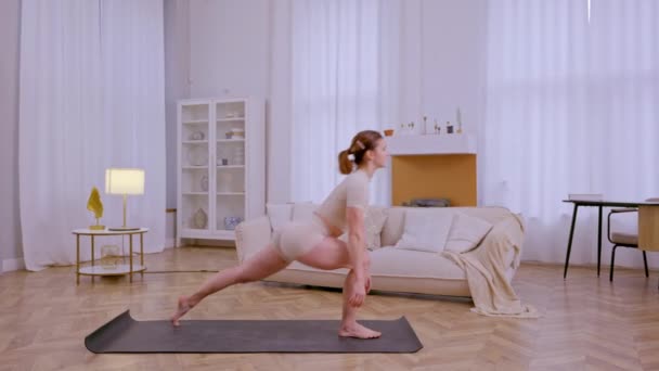 Atletik kız evde esneme hareketleri ve yoga egzersizleri yapıyor. Yüksek kalite 4k görüntü - Video, Çekim