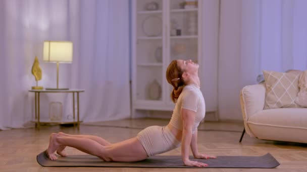 Atletik kız evde esneme hareketleri ve yoga egzersizleri yapıyor. Yüksek kalite 4k görüntü - Video, Çekim