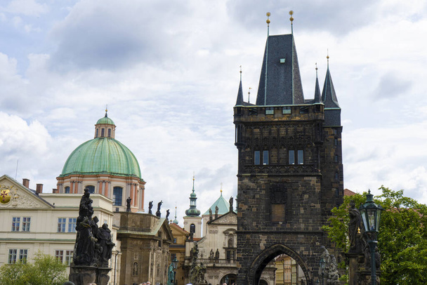 6.8.2023 - Chequia, Praga. Vista de la Torre del Polvo desde el Puente de Carlos en Praga con hermosa arquitectura antigua en el fondo. - Foto, Imagen
