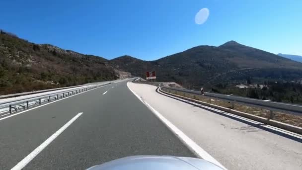 Auto liikkuu moottoritietä pitkin kohti korkeaa vuoristotunnelia. Laadukas 4k kuvamateriaalia - Materiaali, video
