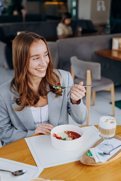 Giovane donna attraente gode pasto gustoso su sfondo caffè o ristorante. Foto di alta qualità - Foto, immagini