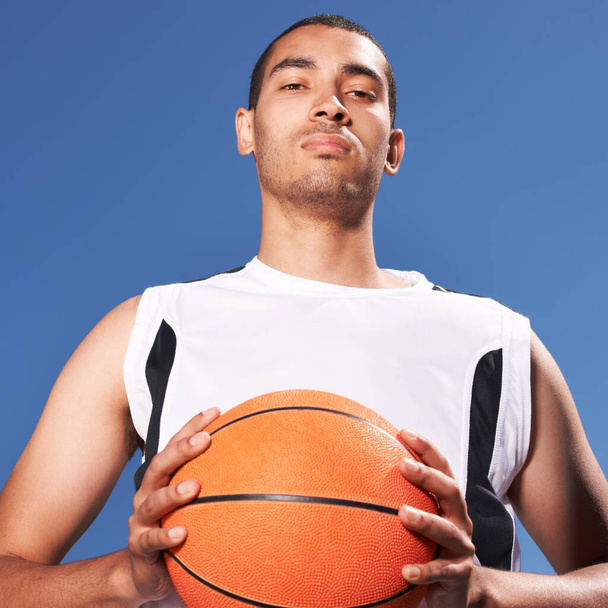 Confident, basketball player and outdoor portrait for sport, game and competition in summer with sky background. Serious, challenge and man with ball for exercise, goals or fitness from training. - Фото, изображение