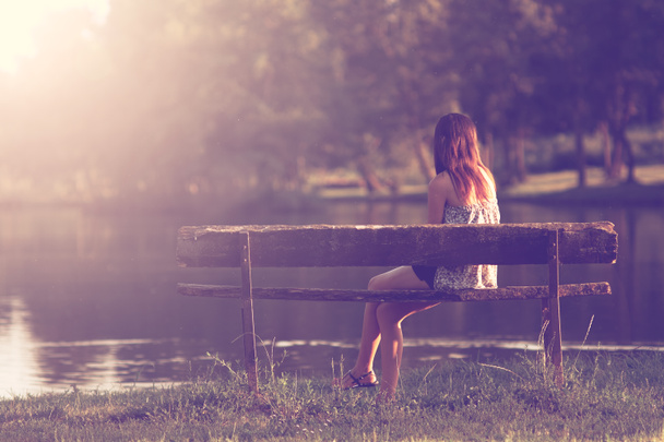 Menina sentada em um banco
 - Foto, Imagem