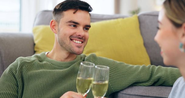 Couple, happy man and champagne for cheers in living room for celebration, anniversary and event. Husband, face and smile with spouse for good news with drink, glass and home for sitting on floor. - Photo, Image