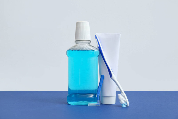 Mundspülung mit Zahnbürste und Zahnpasta auf farbigem Hintergrund. - Foto, Bild